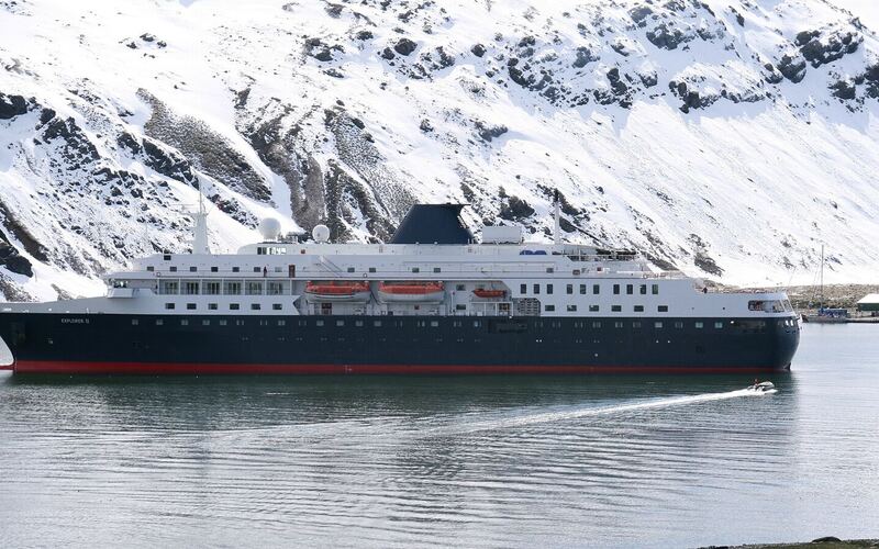 Expeditieschip voor anker in de baai bij Grytviken op Zuid-Georgië, met besneeuwde bergen erachter