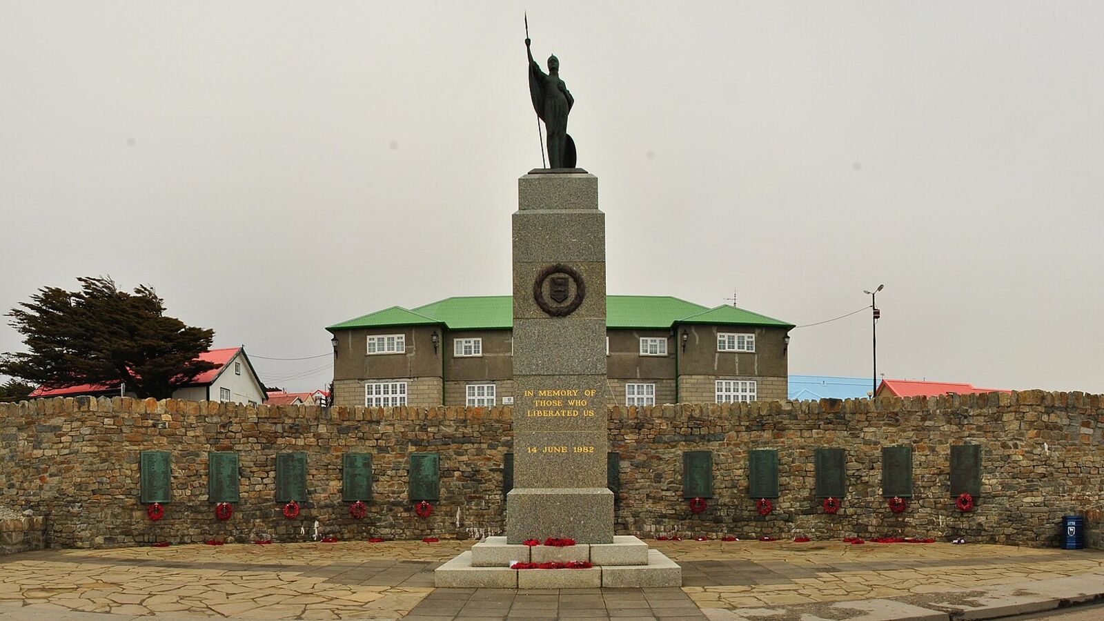 Het 1982 Liberation Memorial in Stanley met een bronzen Britannia op een zuil voor een gebogen muur met gedenkplaten