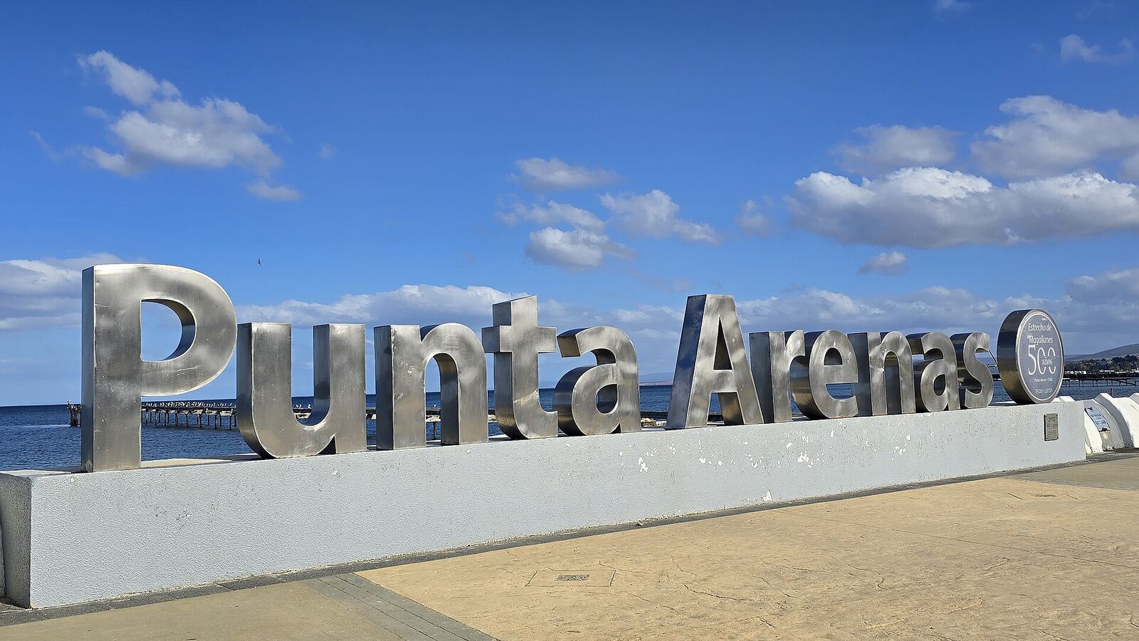 Groot letterbord met de naam Punta Arenas aan de boulevard met de Straat Magellaan op de achtergrond