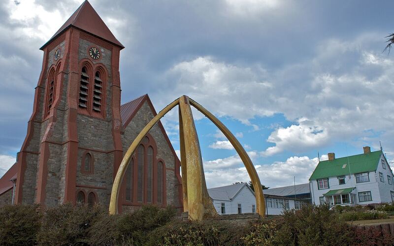 De bakstenen Christ Church Cathedral in Stanley met de boog van walviskaken ervoor